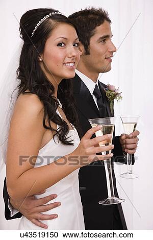 USA, Illinois, Metamora, Studio shot of bride and groom holding champagne flutes View Large Photo Image Stock Image - USA, Illinois, Metamora, Studio shot of bride and groom holding champagne flutes. Fotosearch