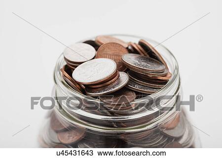 Stock Image - USA, Illinois, Metamora, Studio shot of American coins in jar. Fotosearch