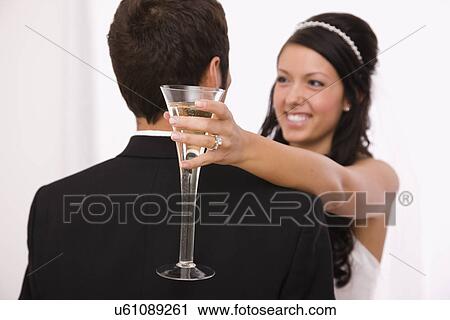Stock Image - USA, Illinois, Metamora, Studio shot of bride and groom dancing. Fotosearch