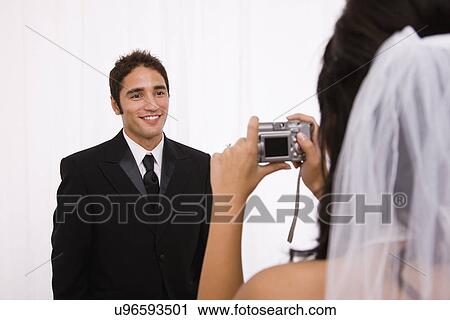 USA, Illinois, Metamora, Studio shot of bride taking groom's picture View Large Photo Image Stock Image - USA, Illinois, Metamora, Studio shot of bride taking groom's picture. Fotosearch