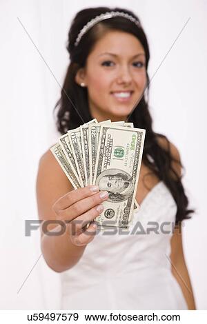 Stock Photo - USA, Illinois, Metamora, Studio shot of bride holding fanned out banknotes. Fotosearch