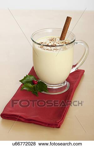 Stock Photo - USA, Illinois, Metamora, Studio shot of eggnog garnished with cinnamon stick and holly. Fotosearch