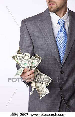 USA, Illinois, Metamora, Studio shot of man in full suit holding one dollar banknotes, mid section View Large Photo Image Stock Photo - USA, Illinois, Metamora, Studio shot of man in full suit holding one dollar banknotes, mid section. Fotosearch