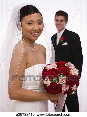Stock Image - USA, Illinois, Metamora, Studio portrait of bride and groom. Fotosearch