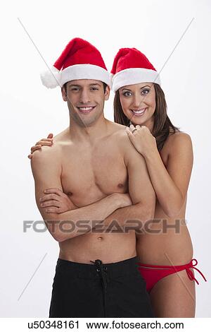 USA, Illinois, Metamora, Studio portrait of couple in swimwear and Santa hats View Large Photo Image Stock Image - USA, Illinois, Metamora, Studio portrait of couple in swimwear and Santa hats. Fotosearch