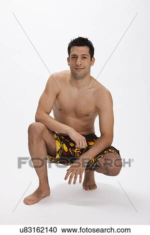 Stock Image - USA, Illinois, Metamora, Studio portrait of man in shorts. Fotosearch