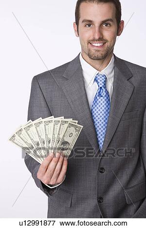 USA, Illinois, Metamora, Studio portrait of business man holding dollar bills View Large Photo Image Stock Photo - USA, Illinois, Metamora, Studio portrait of business man holding dollar bills. Fotosearch