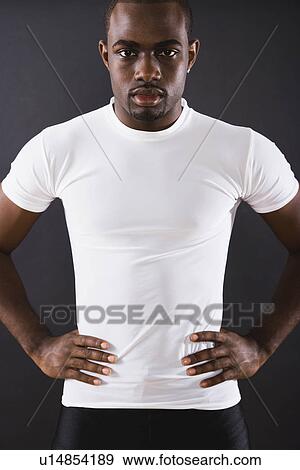 Stock Photo - USA, Illinois, Metamora, studio portrait of young man wearing white t-shirt. Fotosearch