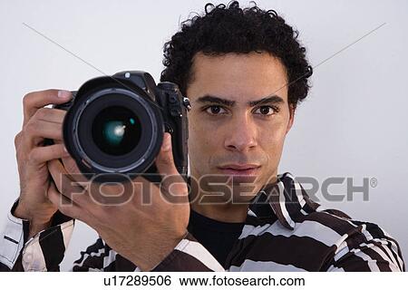 USA, Illinois, Metamora, studio portrait of man taking photo with camera View Large Photo Image Stock Photograph - USA, Illinois, Metamora, studio portrait of man taking photo with camera. Fotosearch