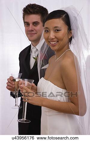 Stock Photograph - USA, Illinois, Metamora, Studio portrait of bride and groom with champagne. Fotosearch