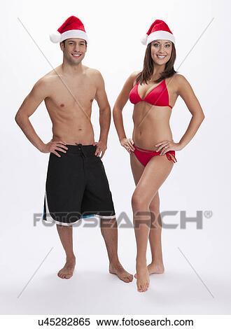 USA, Illinois, Metamora, Studio portrait of couple in swimwear and Santa hats View Large Photo Image Stock Photography - USA, Illinois, Metamora, Studio portrait of couple in swimwear and Santa hats. Fotosearch