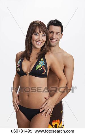 Stock Photography - USA, Illinois, Metamora, Studio portrait of couple in swimwear. Fotosearch