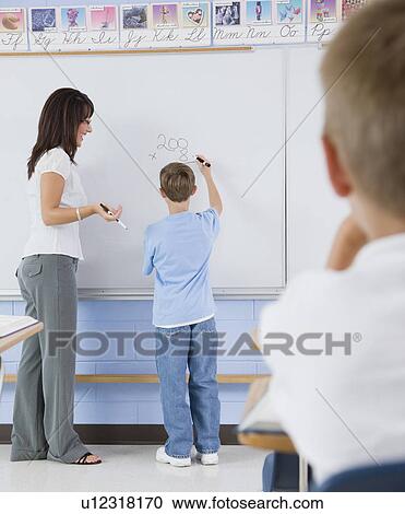 Stock Image - USA, Illinois, Metamora, Teacher and students (8-9) in classroom. Fotosearch