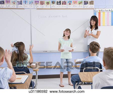 Stock Image - USA, Illinois, Metamora, Teacher and students (8-9) in classroom. Fotosearch