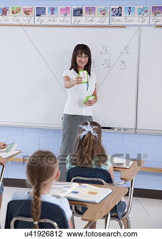 Stock Image - USA, Illinois, Metamora, Teacher and students (8-9) in classroom. Fotosearch
