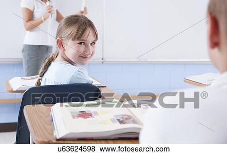 Stock Photo - USA, Illinois, Metamora, Teacher and students (8-9) in classroom. Fotosearch