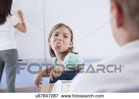 USA, Illinois, Metamora, Teacher and students (8-9) in classroom, girl showing tongue View Large Photo Image Stock Photo - USA, Illinois, Metamora, Teacher and students (8-9) in classroom, girl showing tongue. Fotosearch