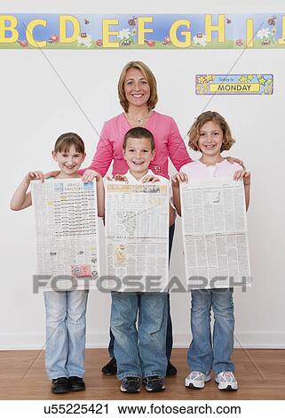 USA, Illinois, Metamora, Teacher standing with children (6-7, 8-9) holding newspapers View Large Photo Image Stock Image - USA, Illinois, Metamora, Teacher standing with children (6-7, 8-9) holding newspapers. Fotosearch