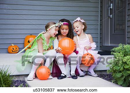 USA, Illinois, Metamora, Three girl (6-7, 8-9) in Halloween costumes sitting and laughing View Large Photo Image Stock Photo - USA, Illinois, Metamora, Three girl (6-7, 8-9) in Halloween costumes sitting and laughing. Fotosearch