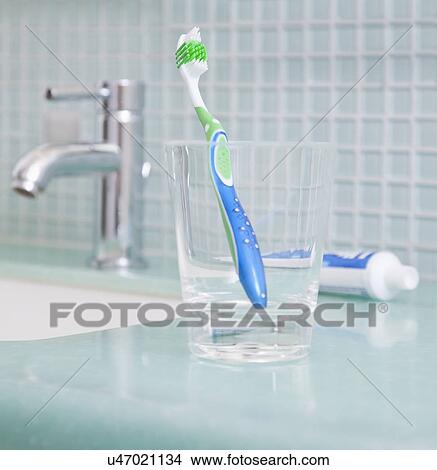 Picture - USA, Illinois, Metamora, toothbrush in glass on sink. Fotosearch