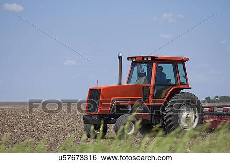 Stock Photograph - USA, Illinois, Metamora, tractor working on field. Fotosearch
