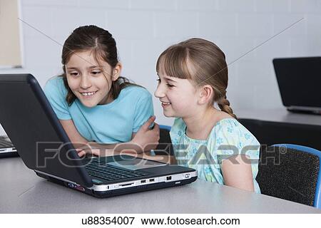 USA, Illinois, Metamora, Two girls looking at laptop (8-9, 10-11) in computer lab View Large Photo Image Stock Photo - USA, Illinois, Metamora, Two girls looking at laptop (8-9, 10-11) in computer lab. Fotosearch