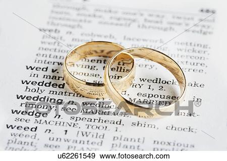Stock Photo - USA, Illinois, Metamora, Two wedding rings on dictionary. Fotosearch
