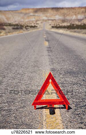 Stock Image - USA, Illinois, Metamora, Warning Triangle on desert road. Fotosearch