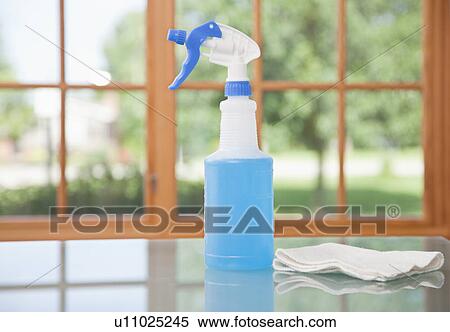 Stock Photography - USA, Illinois, Metamora, windshield wiper fluid and rag on table. Fotosearch