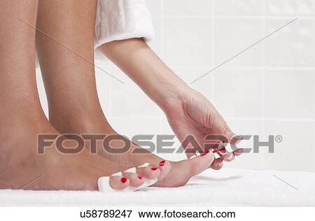 Stock Photo - USA, Illinois, Metamora, woman doing pedicure. Fotosearch