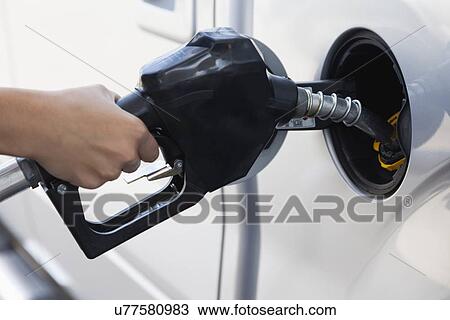 Stock Image - USA, Illinois, Metamora, woman holding fuel pump. Fotosearch