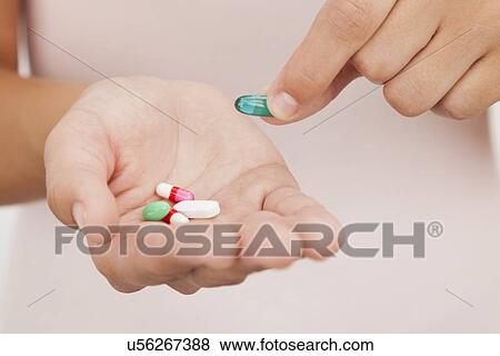 Stock Photo - USA, Illinois, Metamora, Woman holding medicines. Fotosearch