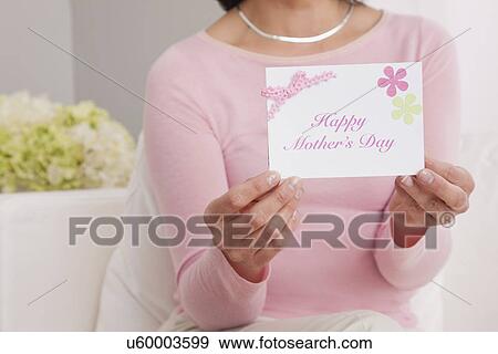 Stock Photo - USA, Illinois, Metamora, woman holding greeting card for mother's day. Fotosearch
