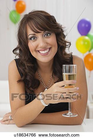 USA, Illinois, Metamora, Woman holding flute of champagne at party View Large Photo Image Stock Photograph - USA, Illinois, Metamora, Woman holding flute of champagne at party. Fotosearch