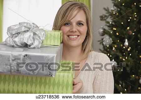 Stock Photograph - USA, Illinois, Metamora, Woman holding stack of gifts. Fotosearch