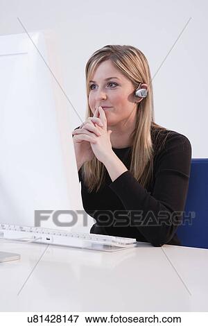 USA, Illinois, Metamora, woman in office wearing blue tooth View Large Photo Image Stock Photo - USA, Illinois, Metamora, woman in office wearing blue tooth. Fotosearch