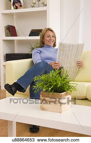 USA, Illinois, Metamora, Woman reading newspaper in living room View Large Photo Image Stock Image - USA, Illinois, Metamora, Woman reading newspaper in living room. Fotosearch