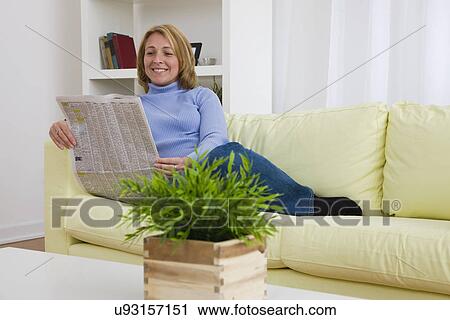 USA, Illinois, Metamora, Woman reading newspaper in living room View Large Photo Image Stock Image - USA, Illinois, Metamora, Woman reading newspaper in living room. Fotosearch
