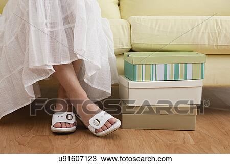 USA, Illinois, Metamora, Woman sitting on sofa in shoe store, low section View Large Photo Image Stock Image - USA, Illinois, Metamora, Woman sitting on sofa in shoe store, low section. Fotosearch
