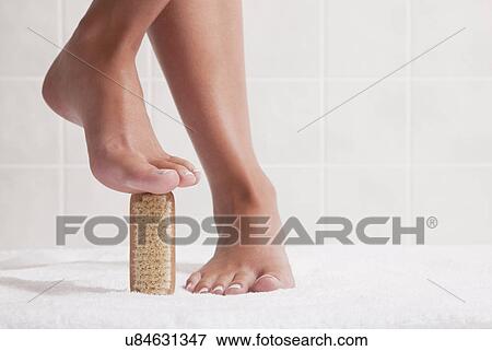 Stock Photo - USA, Illinois, Metamora, woman standing with nail brush under foot. Fotosearch