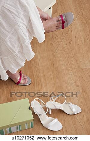 Stock Image - USA, Illinois, Metamora, Woman trying on shoes in store, low section. Fotosearch