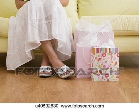 USA, Illinois, Metamora, Woman with shipping bags sitting on sofa in store, low section View Large Photo Image Stock Image - USA, Illinois, Metamora, Woman with shipping bags sitting on sofa in store, low section. Fotosearch