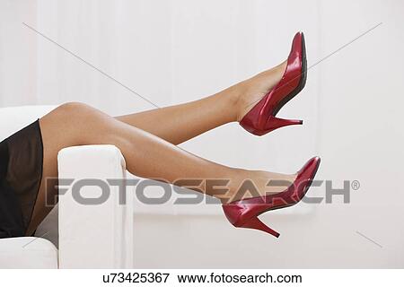 Stock Photo - USA, Illinois, Metamora, Woman's legs over couch. Fotosearch
