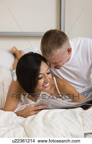Picture - USA, Illinois, Metamora, Young couple in bed. Fotosearch