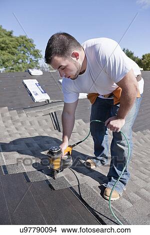 USA, Illinois, Metamora, Young man working on roof with drill View Large Photo Image Picture - USA, Illinois, Metamora, Young man working on roof with drill. Fotosearch