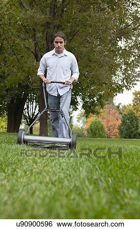 USA, Illinois, Metamora, Young man mowing View Large Photo Image Stock Photograph - USA, Illinois, Metamora, Young man mowing. Fotosearch