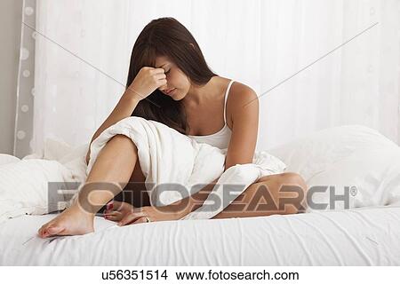USA, Illinois, Metamora, young woman sitting on bed depressed View Large Photo Image Picture - USA, Illinois, Metamora, young woman sitting on bed depressed. Fotosearch