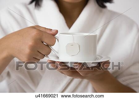 USA, Illinois, Metamora, Young woman holding tea cup View Large Photo Image Stock Image - USA, Illinois, Metamora, Young woman holding tea cup. Fotosearch
