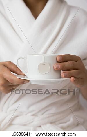 USA, Illinois, Metamora, Young woman holding tea cup View Large Photo Image Stock Image - USA, Illinois, Metamora, Young woman holding tea cup. Fotosearch