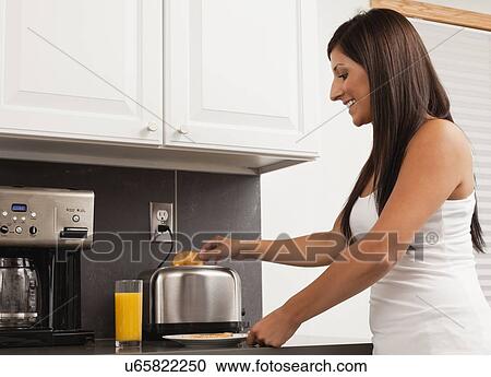 Stock Image - USA, Illinois, Metamora, young woman making toasts. Fotosearch